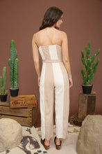 Load image into Gallery viewer, brunette female facing backward wearing tan and ivory jumpsuit