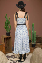 Load image into Gallery viewer, Girl in blue floral dress facing backwards 
